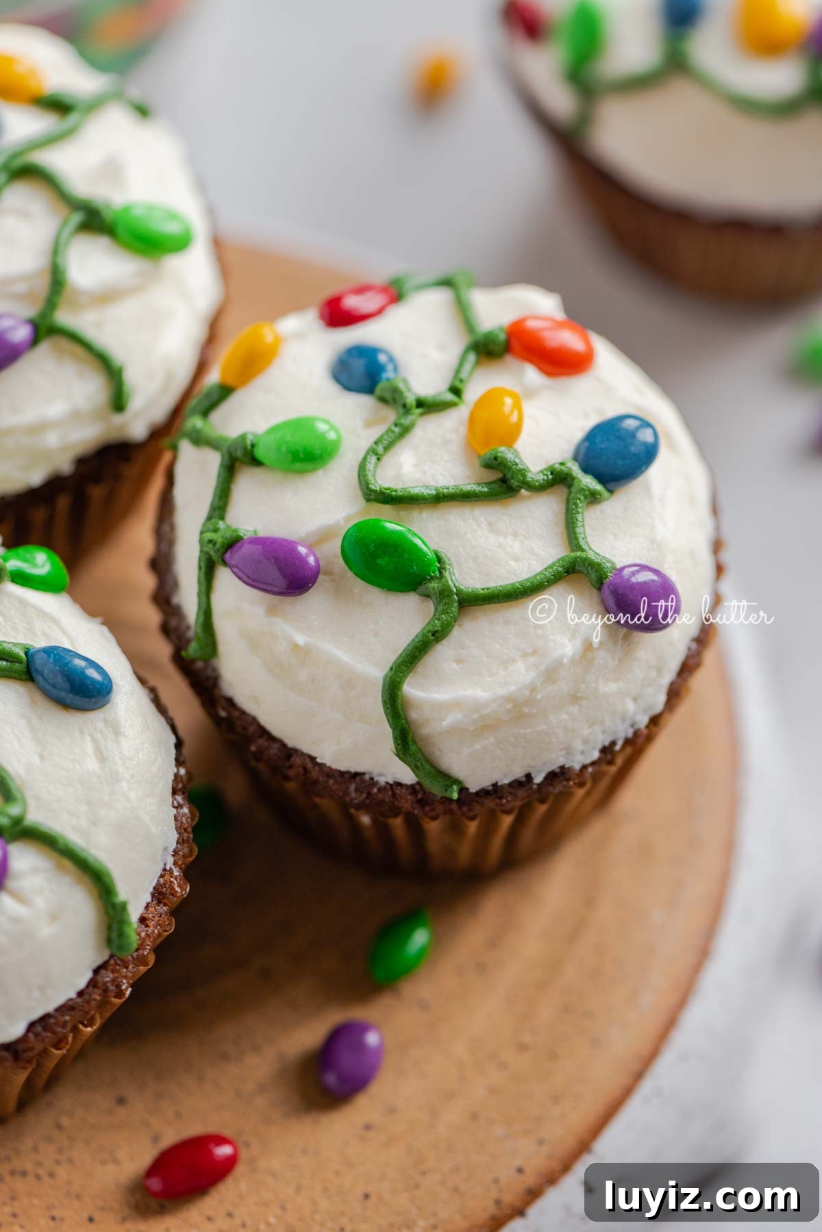 Gingerbread Cupcakes Recipe for a Small Batch (6 Muffins) 3 Small batch of gingerbread cupcakes on an upside down pie plate on a white background with scattered chocolate covered sunflower seeds | All Images © Beyond the Butter®