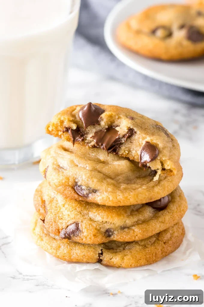 Chewy Chocolate Chip Pudding Cookies Recipe 5 A stack of pudding chocolate chip cookies with one cookie broken in half to show the thick, extra soft center.