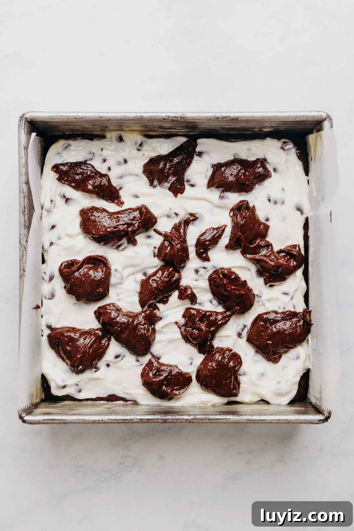 Cream Cheese Swirled Chocolate Chip Brownies 14 Dollops of reserved brownie batter placed on top of the cream cheese layer.