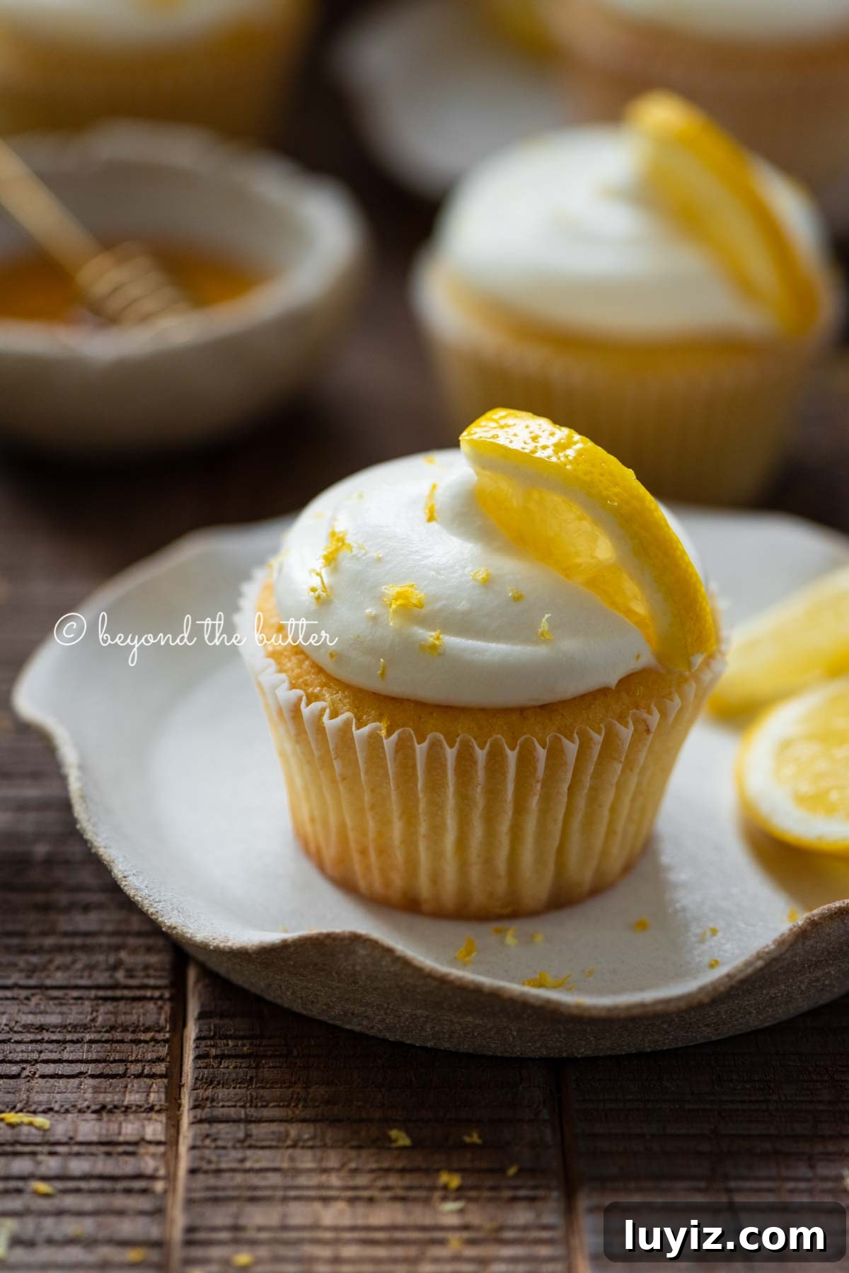 Mini Lemon Cupcakes: Perfect Small-Batch Recipe for 6-8 Servings 5 Lemon cupcakes with lemon cream cheese frosting garnished with lemons on small wavy dessert plates