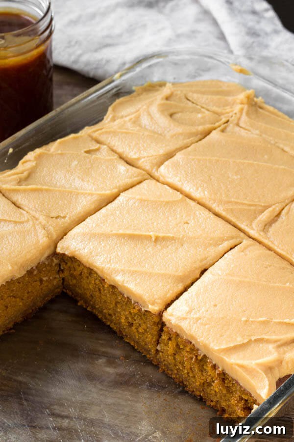 A pan of flavorful pumpkin cake with caramel cream cheese frosting. 