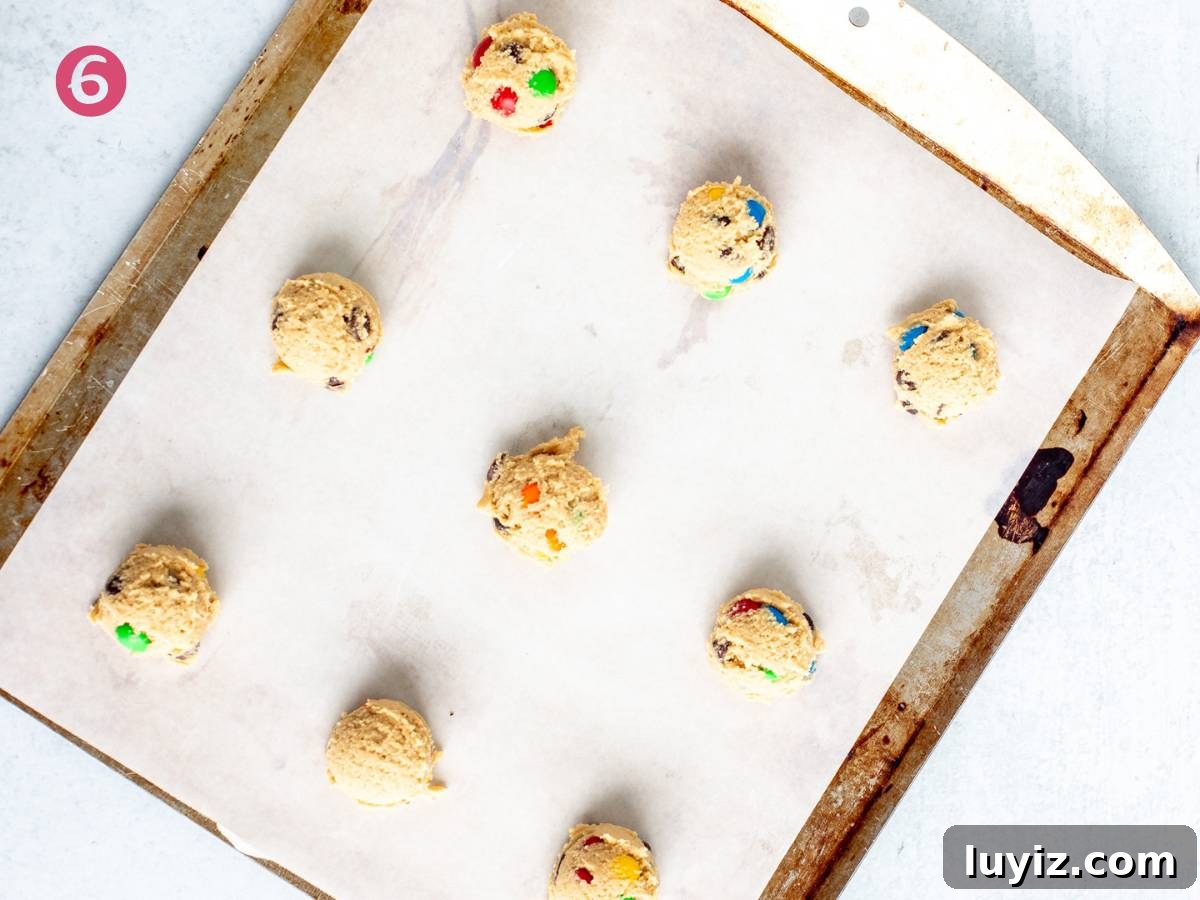 Soft & Chewy M&M Cookies That Melt in Your Mouth 6 Lined cookie sheet with M&M cookie dough balls