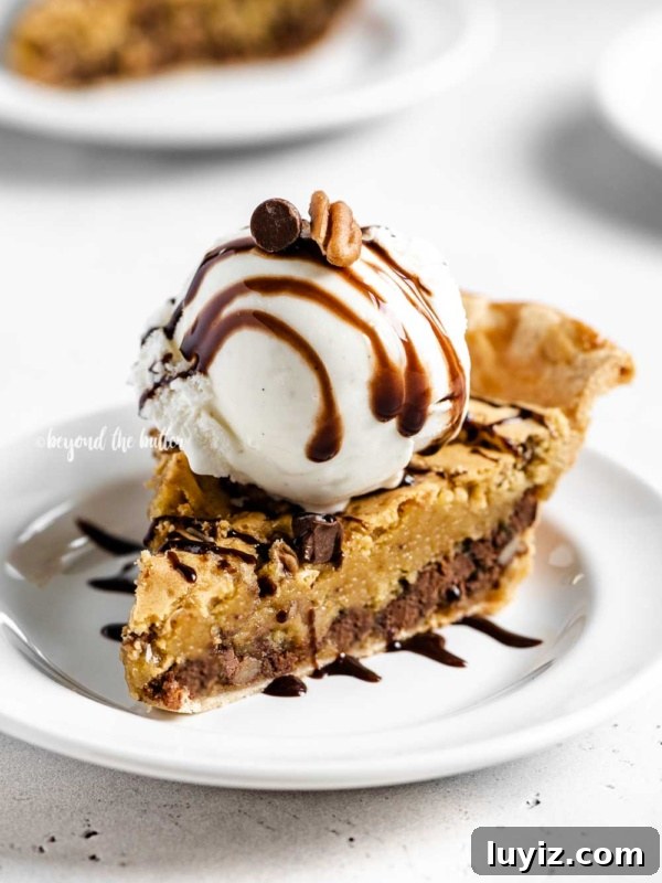 Classic Lemon Sponge Pie Recipe — Light, Zesty Dessert 13 Angled closeup image of Chocolate Chip Pie with a scoop of vanilla ice cream on top that's drizzled with chocolate syrup.