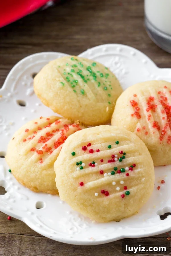 Light and Fluffy Whipped Shortbread Cookies Recipe 3 A plate of whipped shortbread cookies with holiday sprinkles.