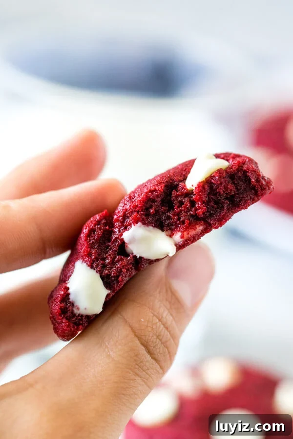 Red Velvet Cake Mix Cookies Recipe — Soft, Chewy Treats 5 Half of a red velvet cake mix cookie, held between thumb and index finger.
