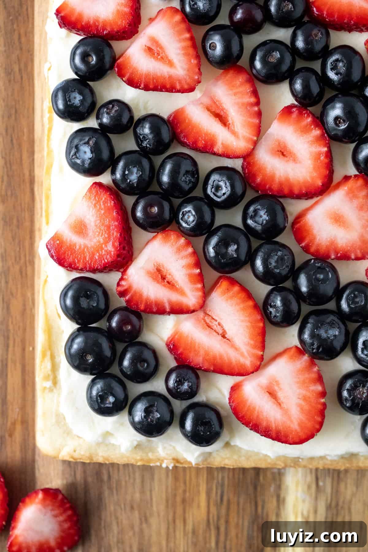 Berry-Topped Sugar Cookie Bars Recipe 3 Slab of sugar cookie bars with vanilla frosting and topped with blueberries and sliced strawberries