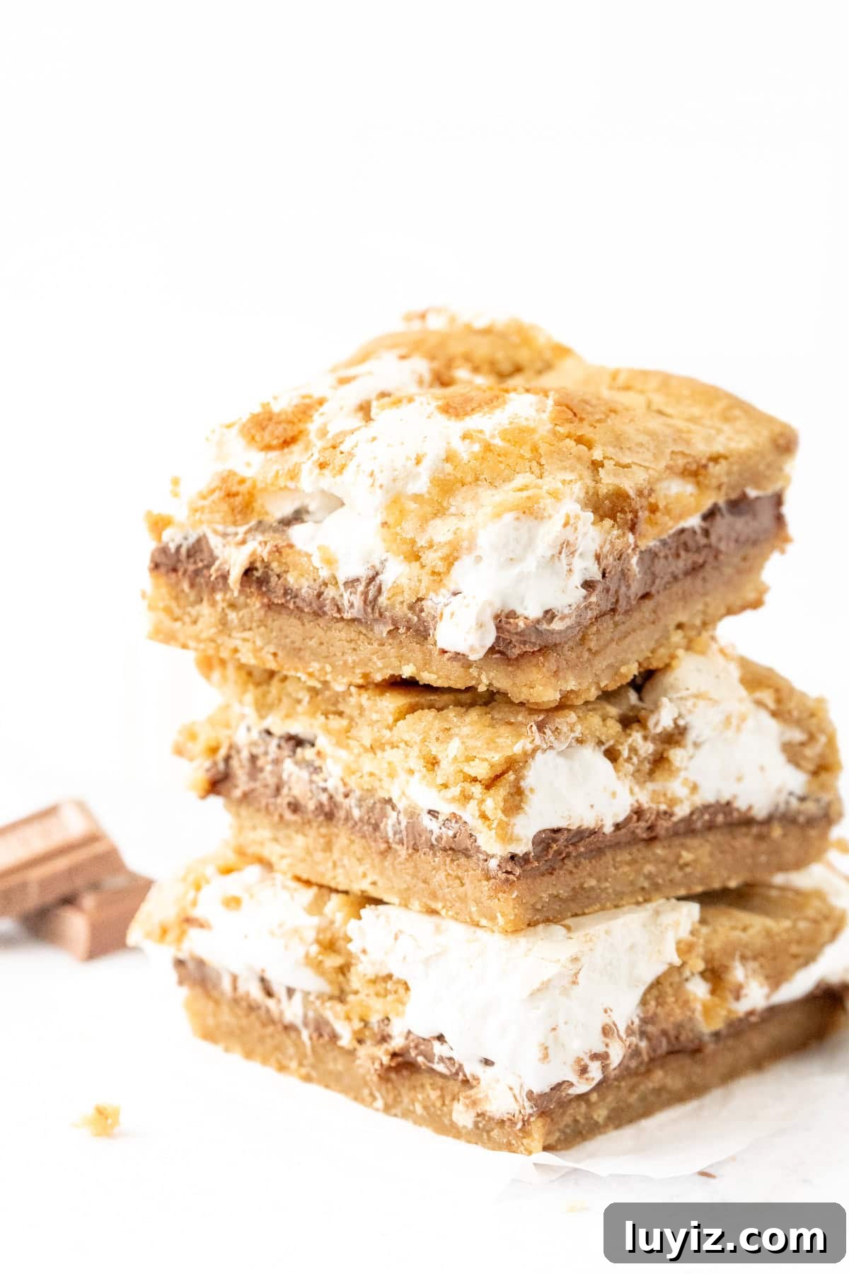 Stack of three s'mores cookie bars with chocolate and marshmallow cream in the middle