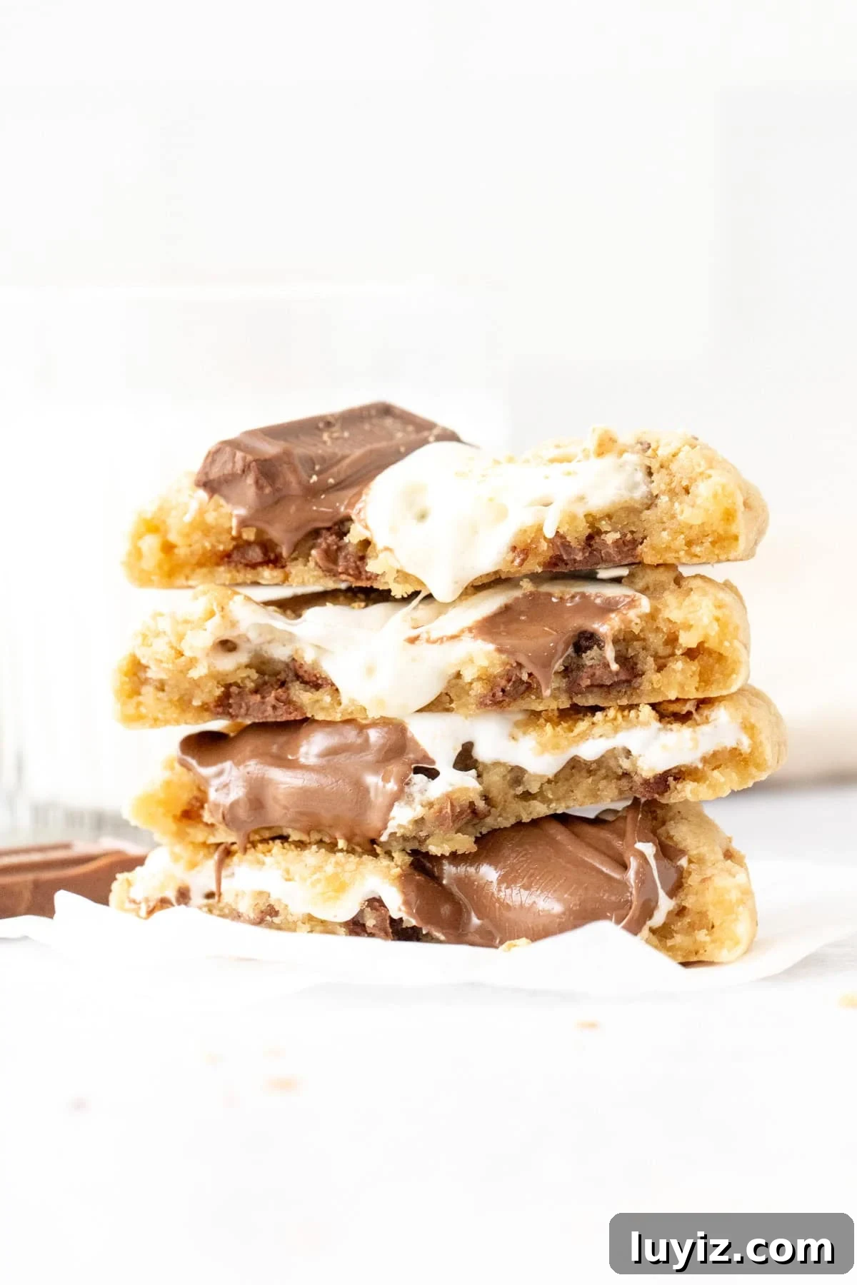 Stack of gooey s'mores cookies with marshmallow and melted milk chocolate, broken in half and stacked