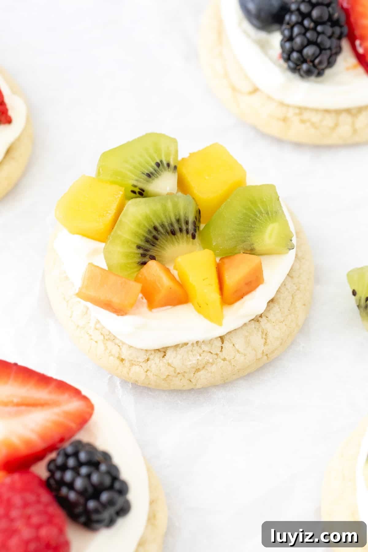 Mini Fruit Pizza Bites: Party Dessert Recipe 3 Mini fruit pizza with cream cheese frosting and tropical fruit on top