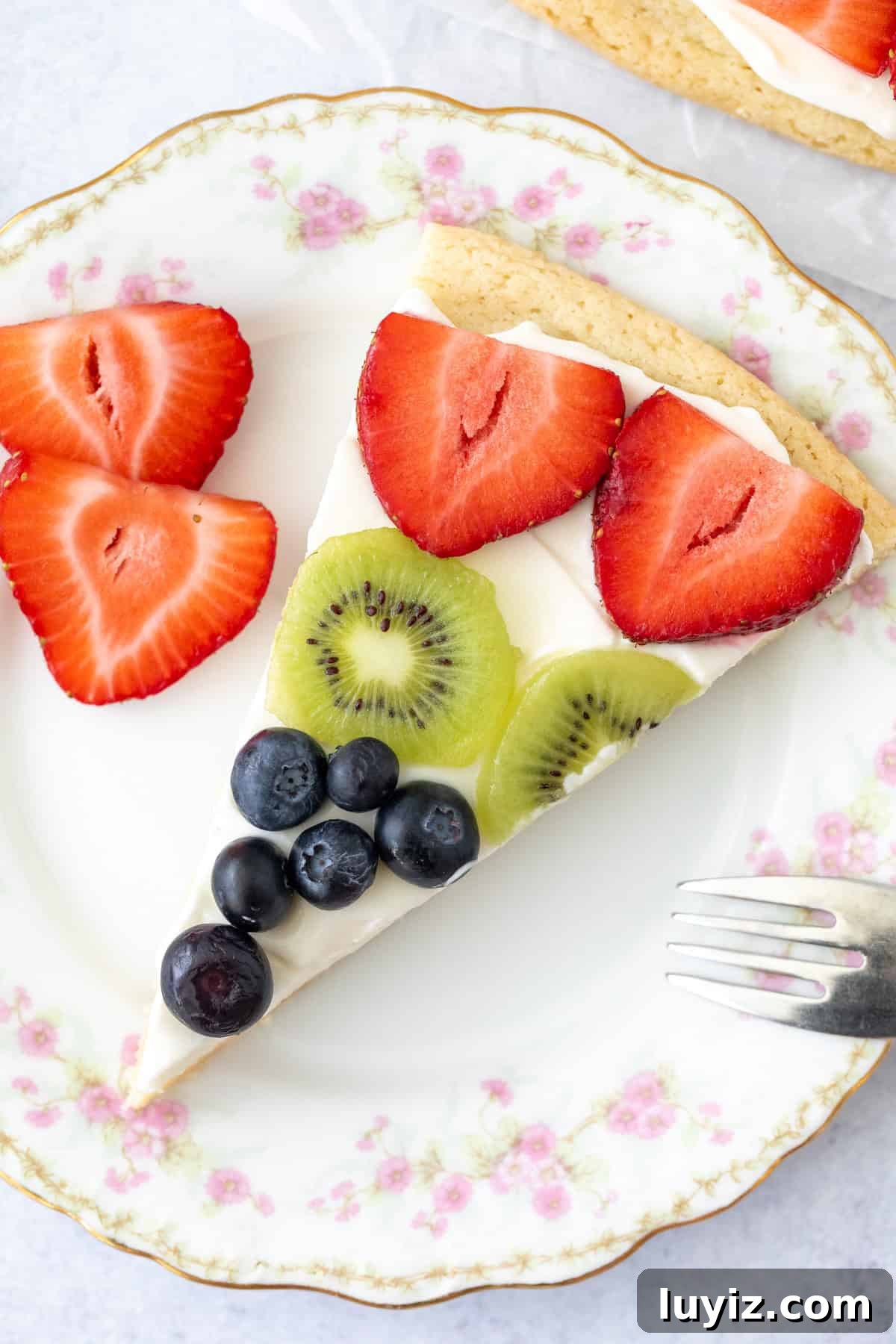 Slice of sugar cookie fruit pizza on a plate