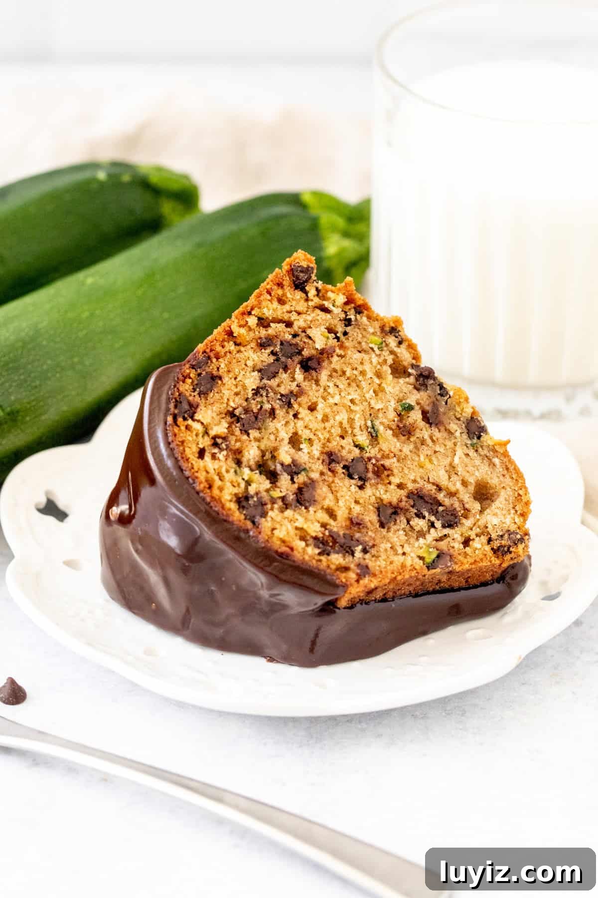 Moist Chocolate Chip Zucchini Cake Recipe 3 slice of zucchini bundt cake with chocolate chips and chocolate drizzle on top