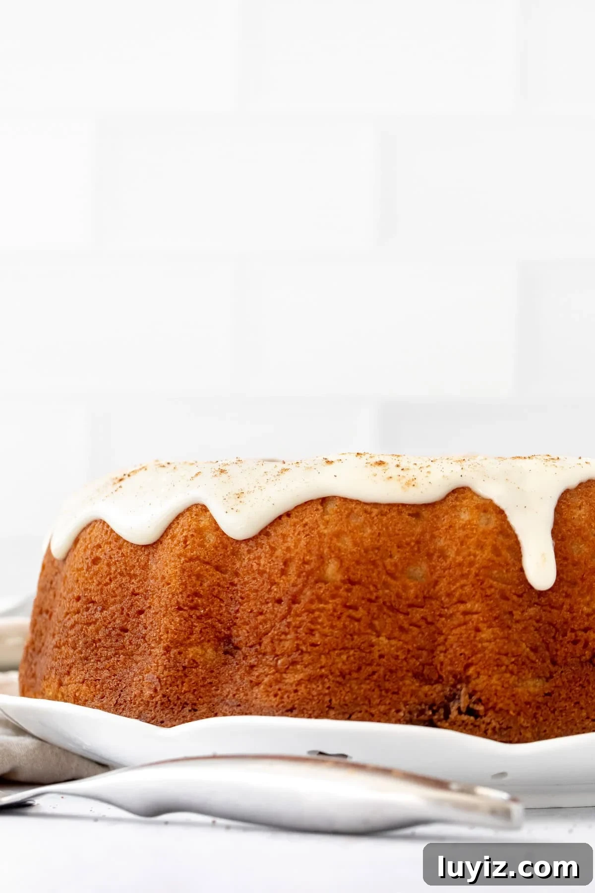 Cinnamon Swirl Bundt Cake with Cream Cheese Glaze 3 cinnamon roll bundt cake topped with cream cheese icing and a sprinkle of cinnamon