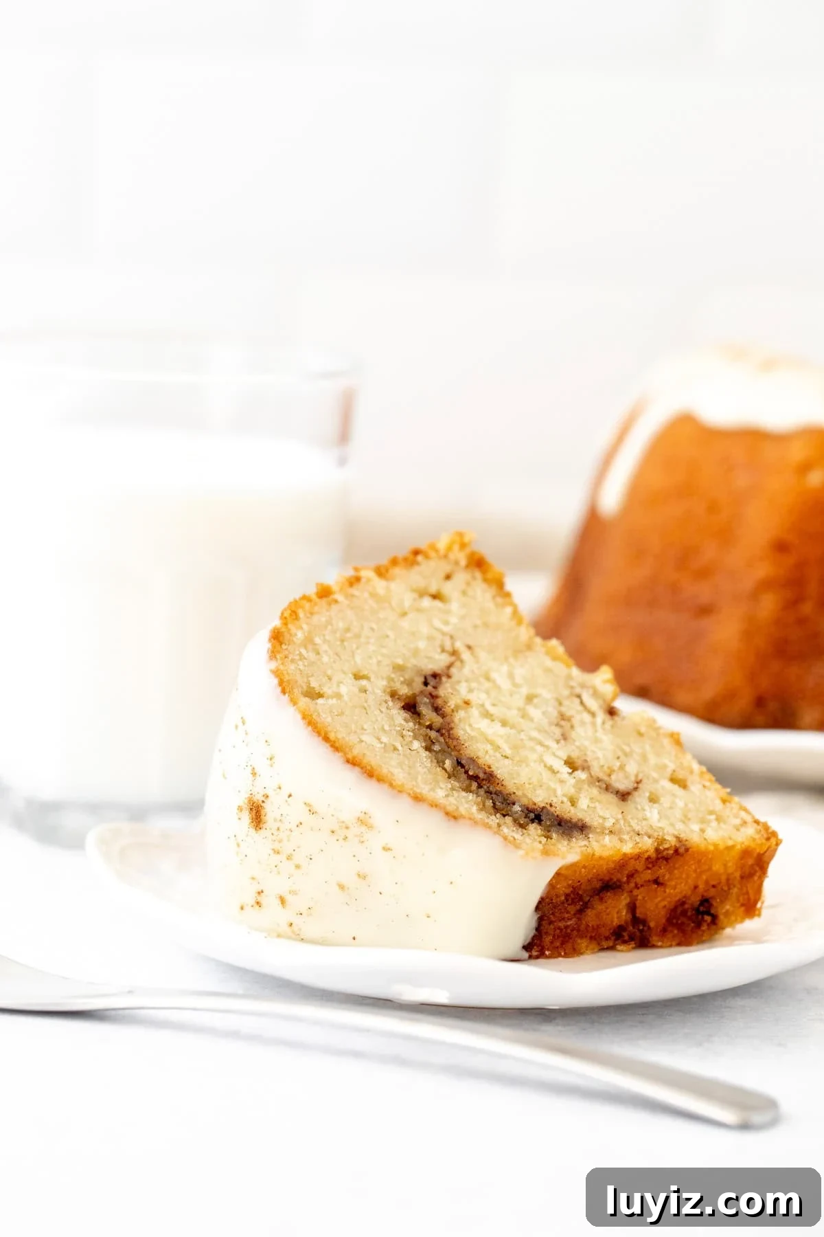Cinnamon Swirl Bundt Cake with Cream Cheese Glaze 5 Slice of cinnamon bundt cake with cream cheese icing on top