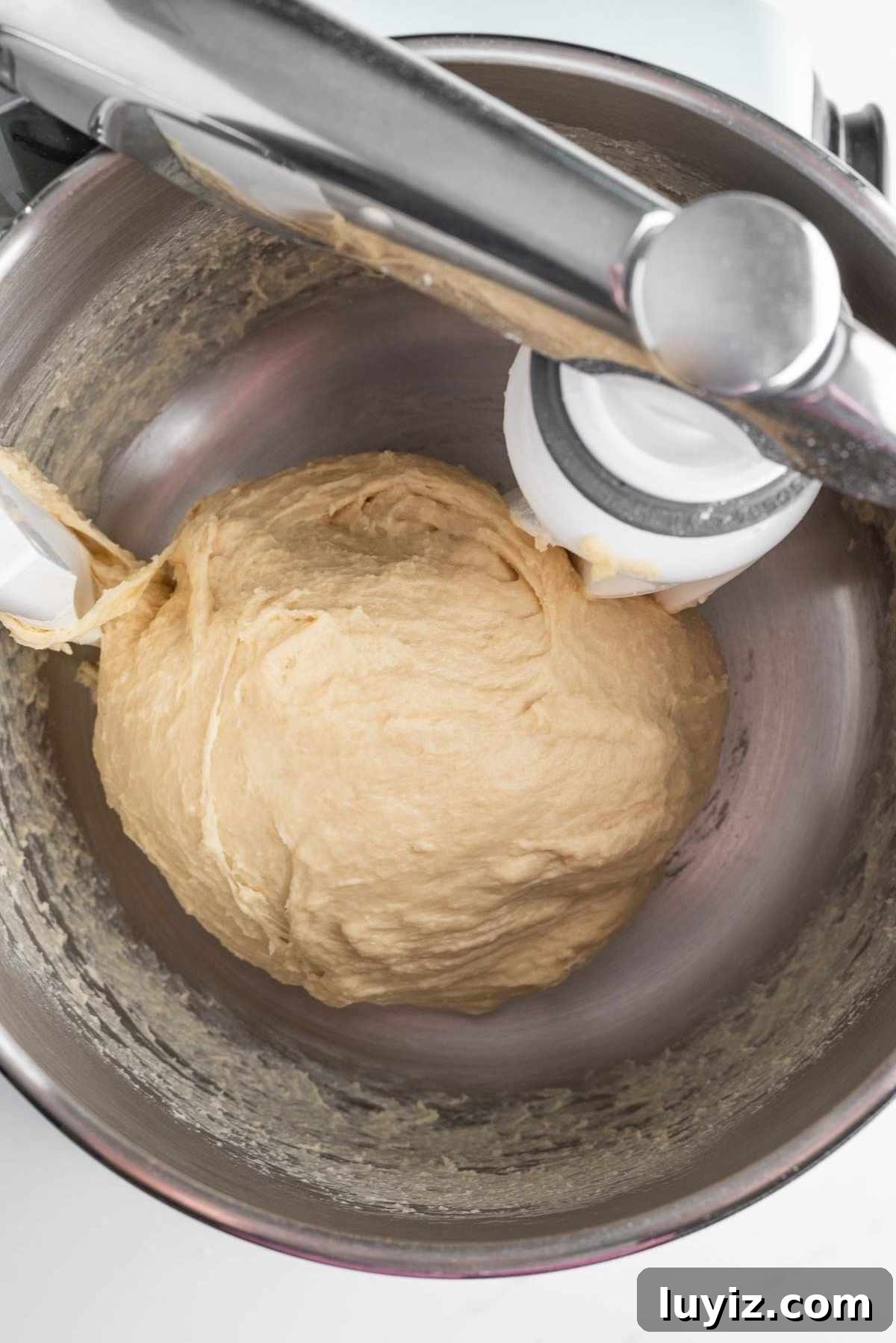 Kneaded cinnamon roll dough in a bowl.