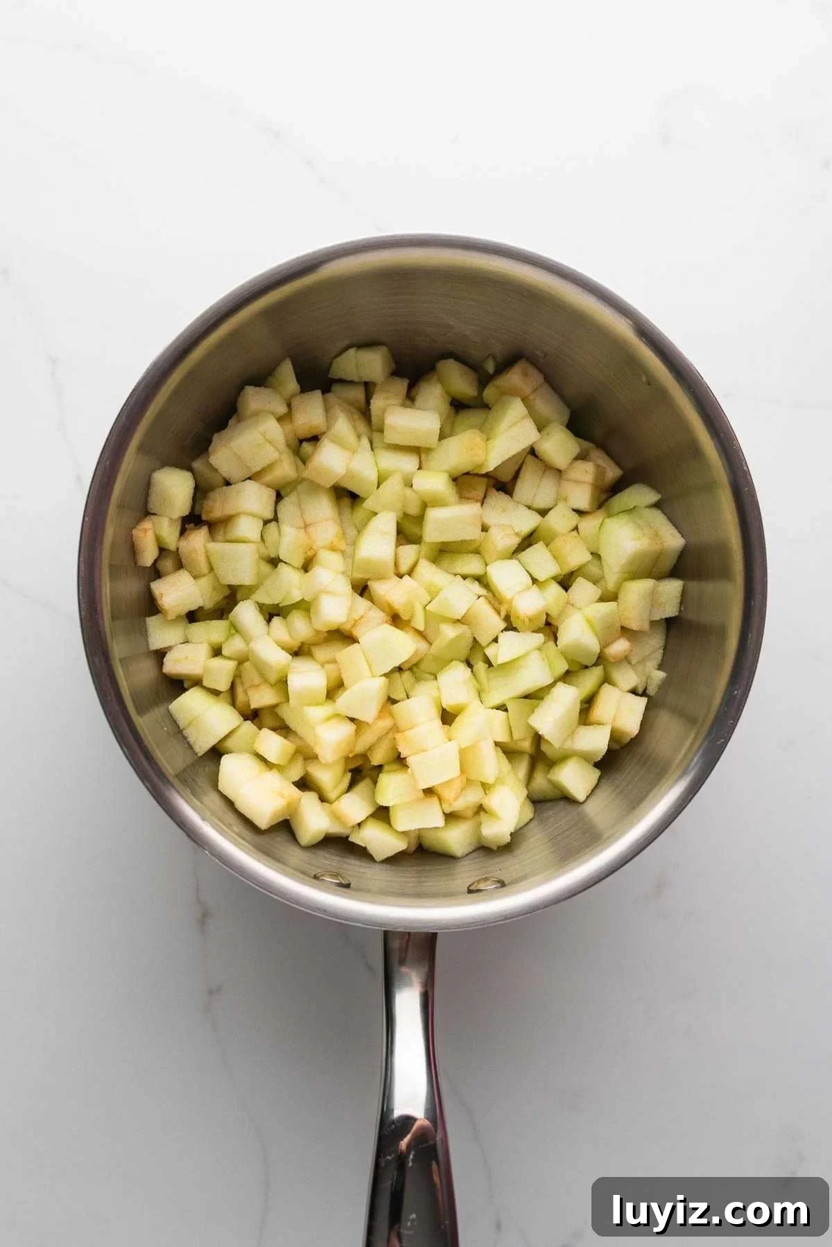 Peeled and chopped apples in a saucepan.