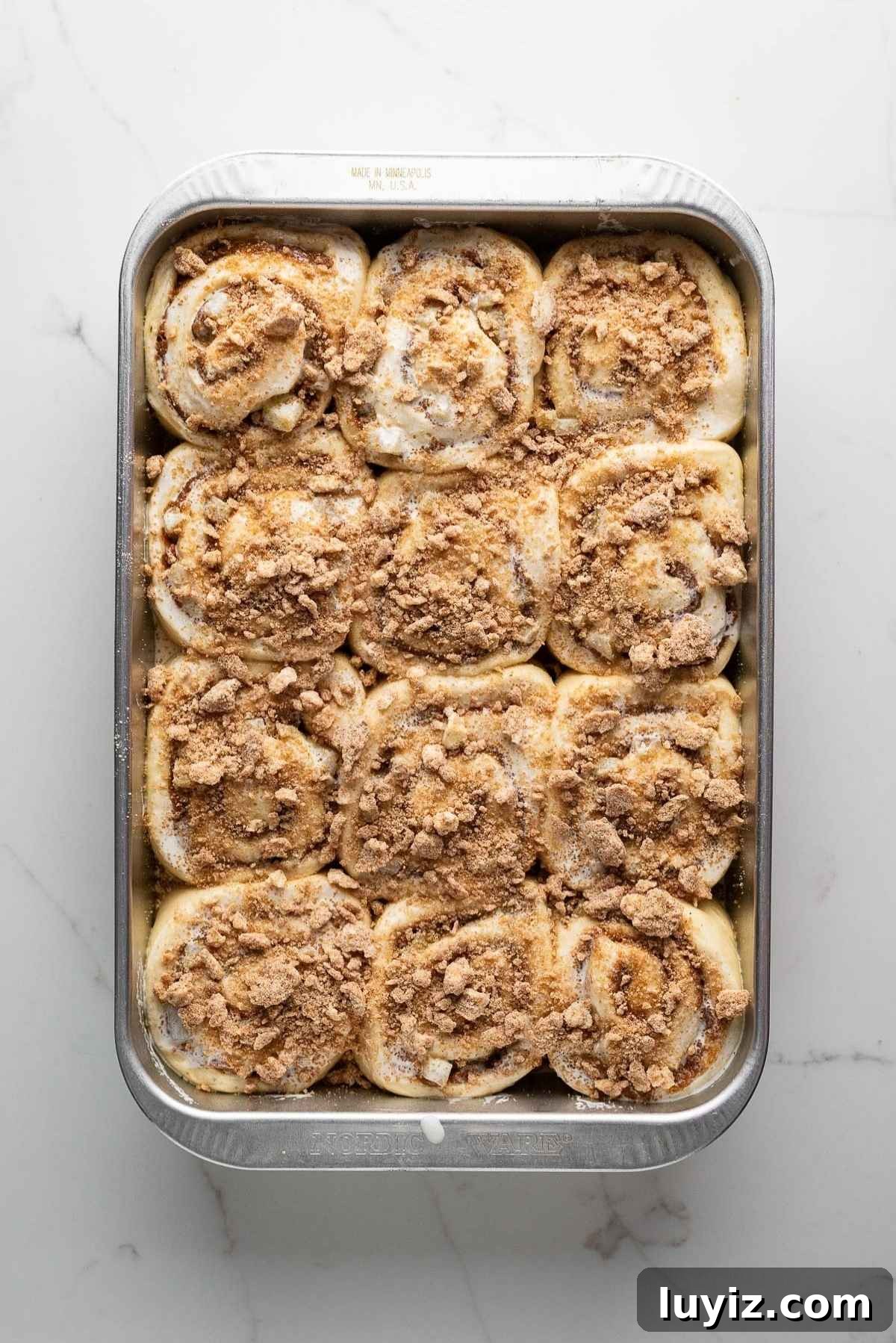 Cinnamon rolls topped with heavy cream and streusel.