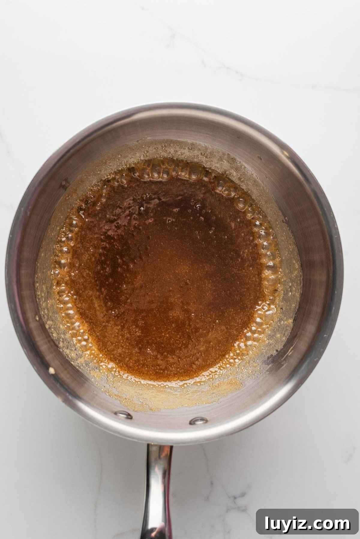 Brown sugar, butter, and heavy cream heating in a saucepan.