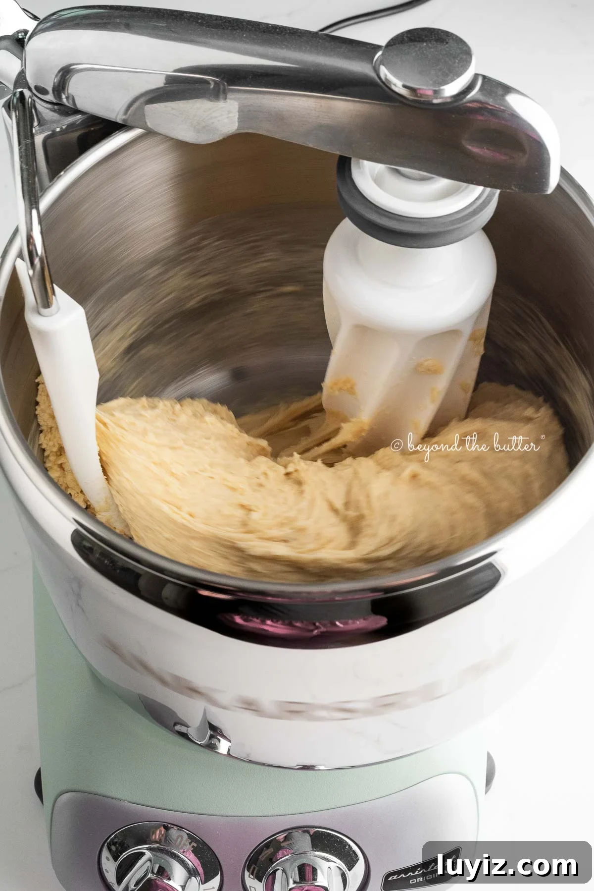 Cinnamon roll dough being kneaded in a mixer.