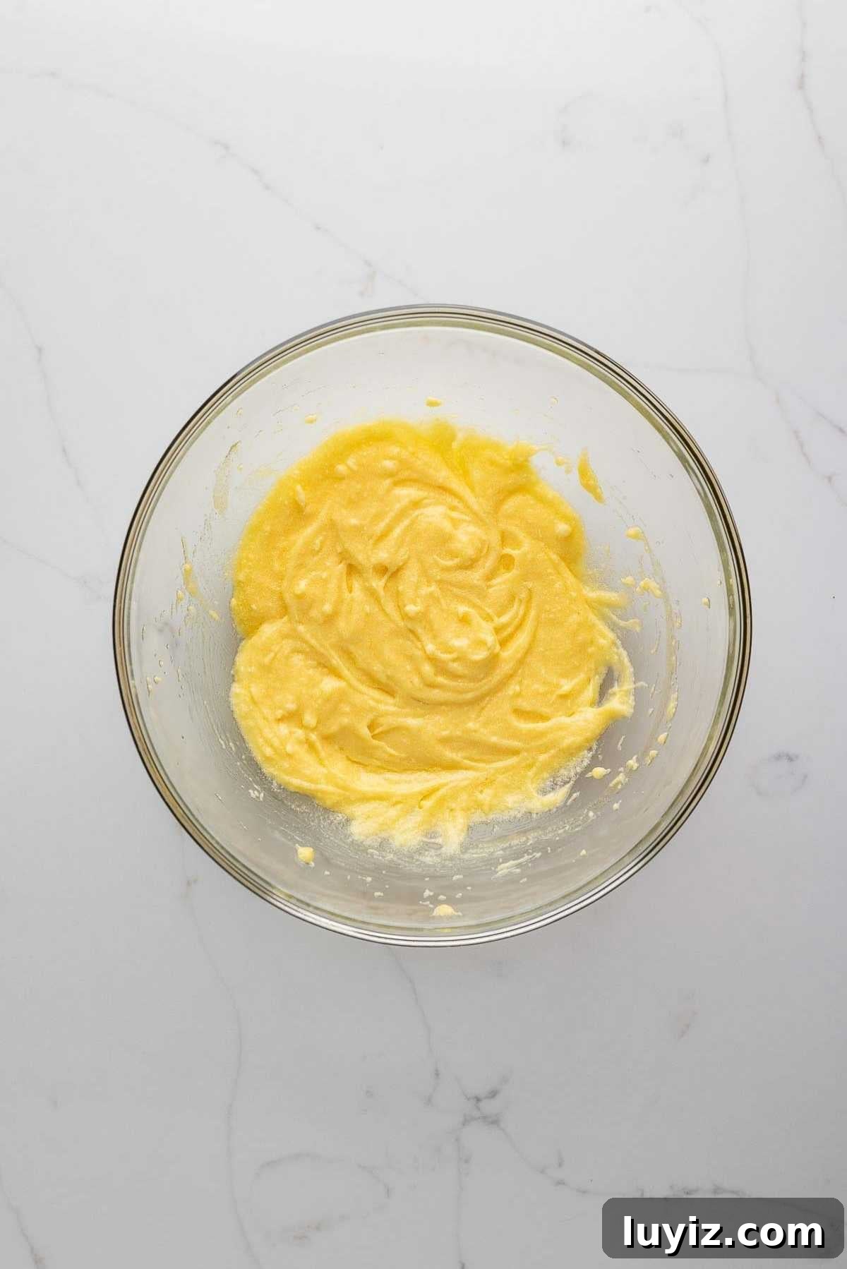 Butter, egg, sugar, and salt mixed in a bowl.